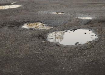 Asfalto bagnato, buca piena d’acqua: chi cade sulla strada o sulla …