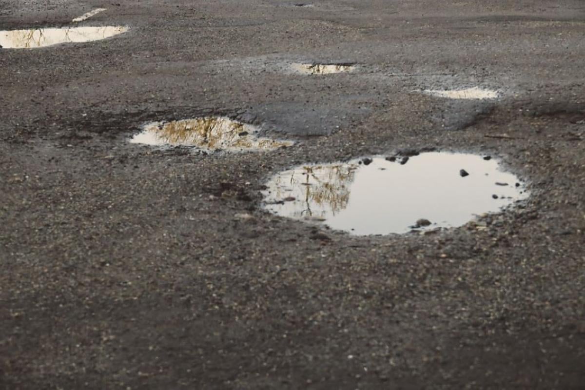 Asfalto bagnato, buca piena d’acqua: chi cade sulla strada o sulla …