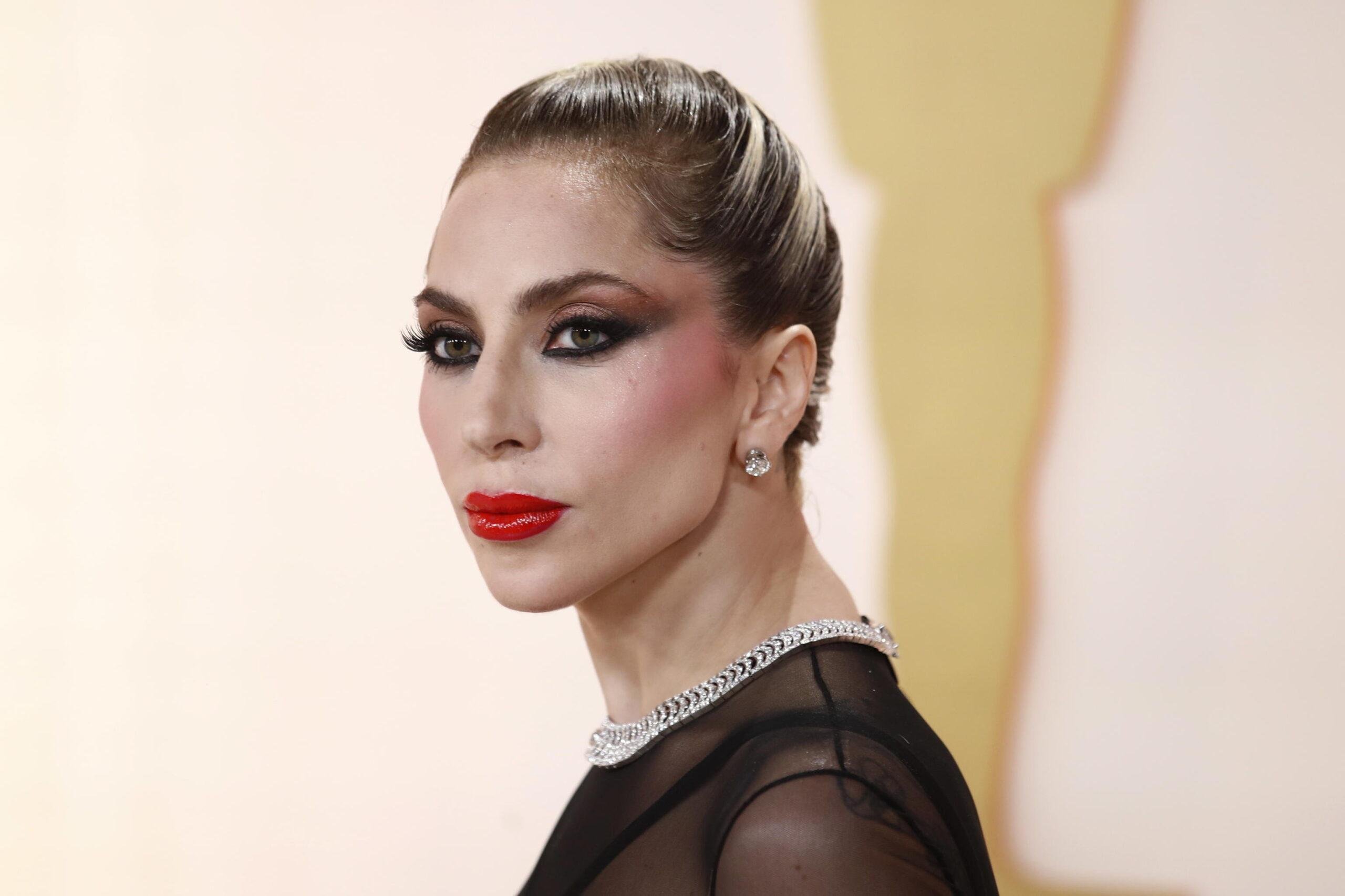 Oscar 2023, Lady Gaga soccorre un fotografo caduto sul red carpet. Fan furiosi: “Lui le ha dato una pacca sul sedere”