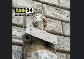 Cartello sulla Statua di Pasquino a Roma: la scritta “Stop ai sussidi fossili” è una freccia scoccata dagli attivisti per il clima di Extinction Rebellion | FOTO