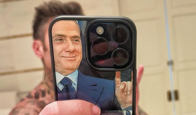 L'ultima provocazione di Fedez, la cover del telefono con l'iconica immagine di Berlusconi che fa le corna al vertice Ue. Social divisi